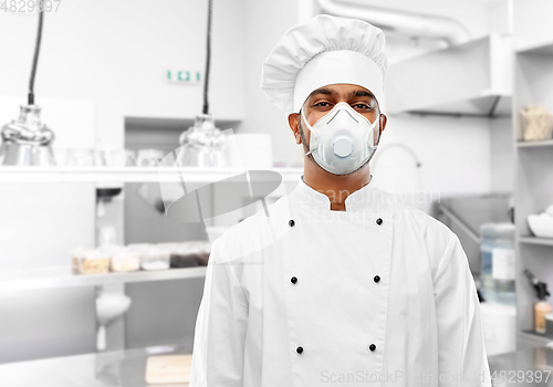 Image of male chef in respirator at restaurant kitchen