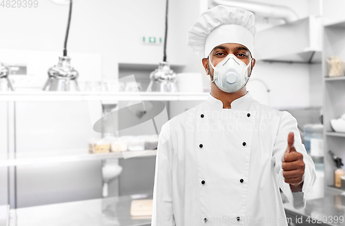 Image of chef in respirator showing thumbs up at kitchen