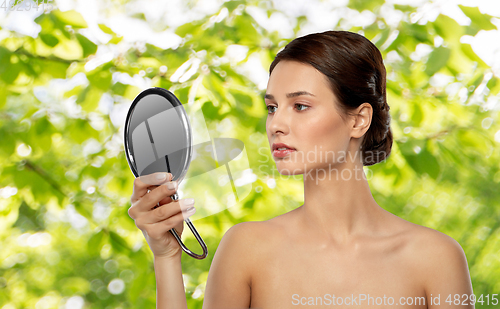 Image of beautiful young woman looking to mirror