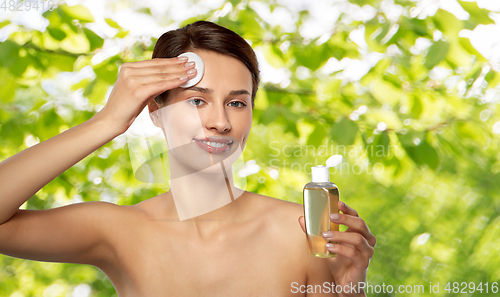 Image of young woman with toner or cleanser and cotton pad