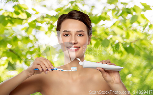 Image of smiling woman with toothbrush cleaning teeth