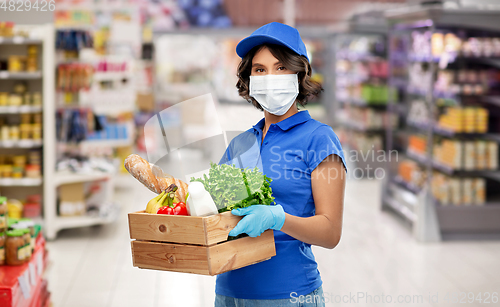 Image of delivery girl in mask with food in box at store
