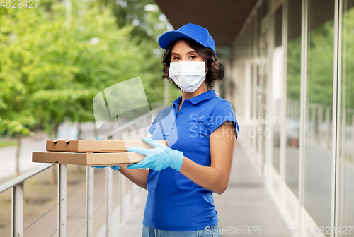 Image of delivery woman in face mask with pizza boxes