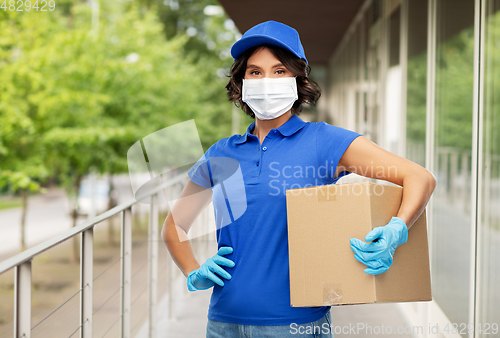 Image of delivery woman in face mask holding parcel box