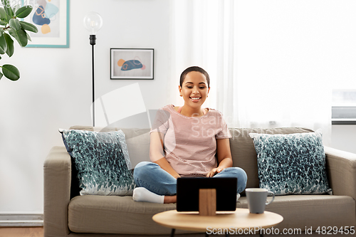 Image of african american woman with tablet pc at home