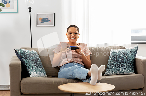 Image of african american woman with gamepad playing game