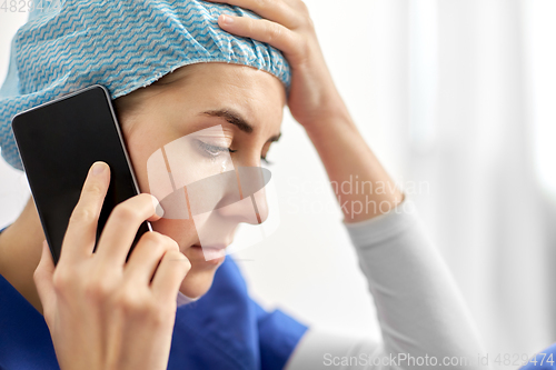 Image of sad doctor or nurse calling on smartphone