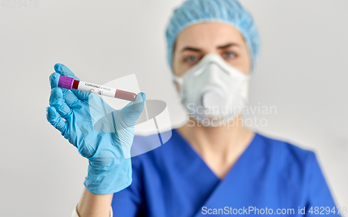 Image of doctor holding beaker with coronavirus blood test