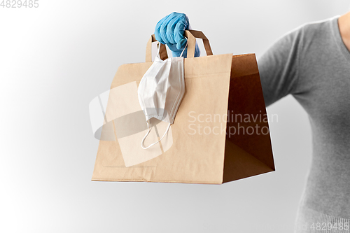 Image of woman with shopping bag, face mask and gloves