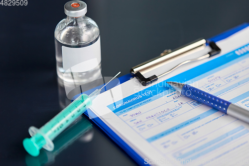 Image of medical report, pen, syringe and medicine