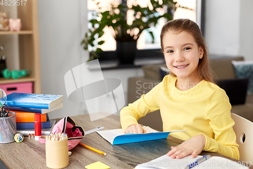 Image of student girl with book and notebook at home