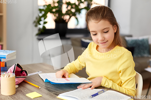 Image of student girl with book and notebook at home