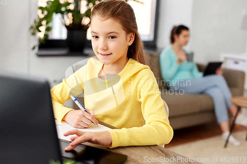 Image of student girl with laptop learning online at home