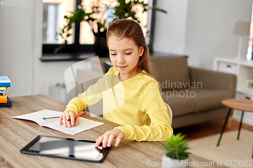 Image of student girl writing to notebook at home