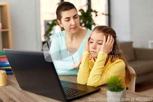 Image of mother and daughter with laptop doing homework