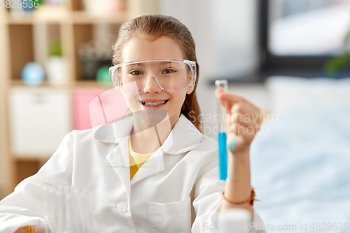 Image of girl with test tube studying chemistry at home