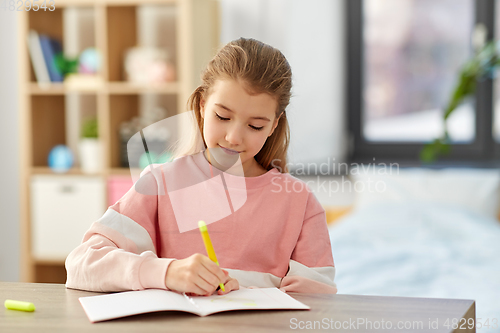 Image of girl with notebook and marker drawing at home