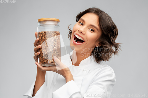 Image of happy female chef with buckwheat in glass jar