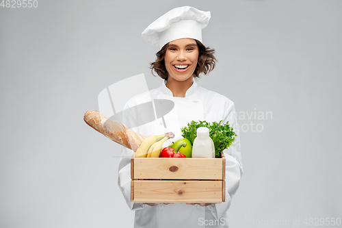 Image of happy smiling female chef with food in wooden box