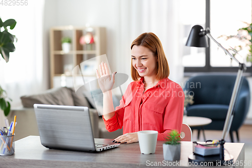 Image of woman with laptop having video call at home office