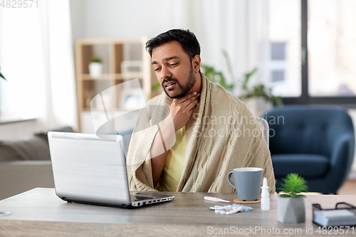 Image of sick indian man having video call on laptop
