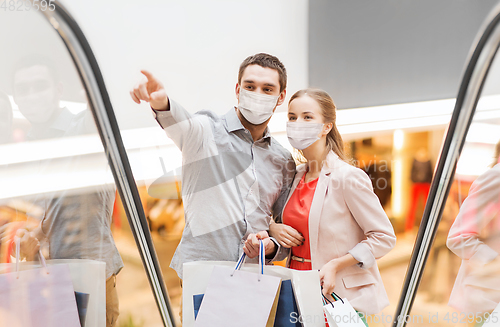 Image of happy young couple with shopping bags in mall