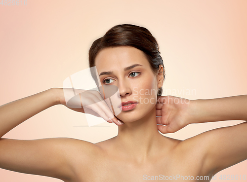 Image of beautiful young woman touching her face