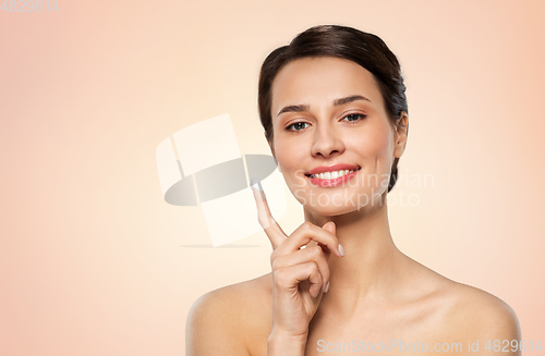 Image of young woman with moisturizing cream on finger