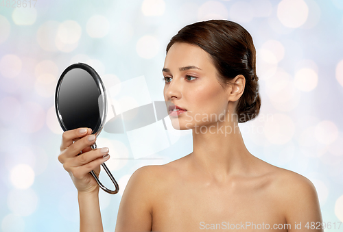 Image of beautiful young woman looking to mirror