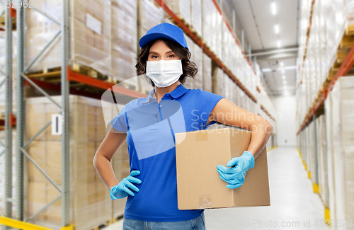 Image of delivery woman in face mask holding parcel box