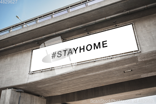 Image of billboard with stay home words on concrete bridge