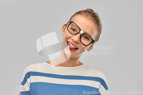 Image of teenage student girl in glasses showing tongue