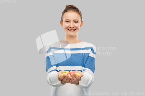 Image of happy smiling teenage girl holding candies