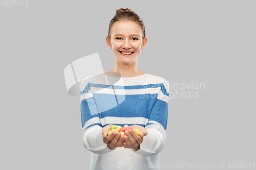 Image of happy smiling teenage girl holding candies