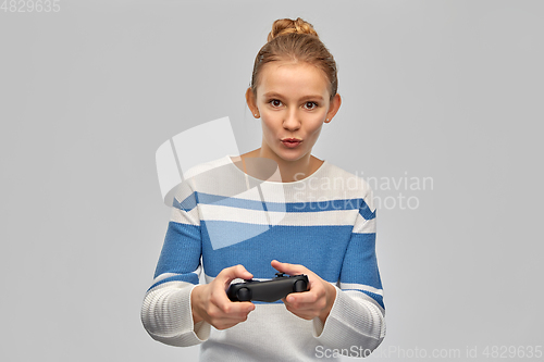 Image of happy teenage girl with gamepad playing video game