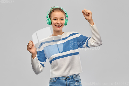 Image of happy smiling teenage girl in headphones dancing