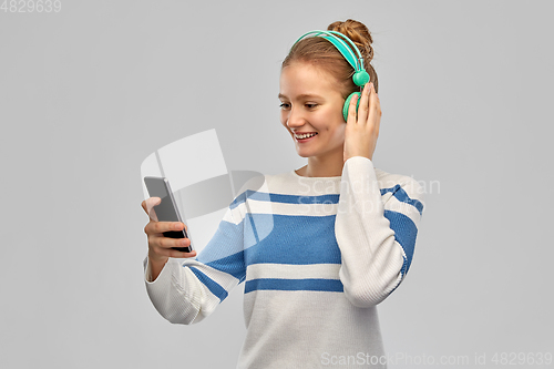 Image of smiling teenage girl in headphones with smartphone