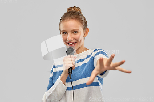 Image of smiling teenage girl with microphone singing