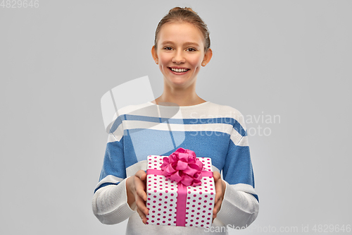 Image of smiling teenage girl in pullover with gift box
