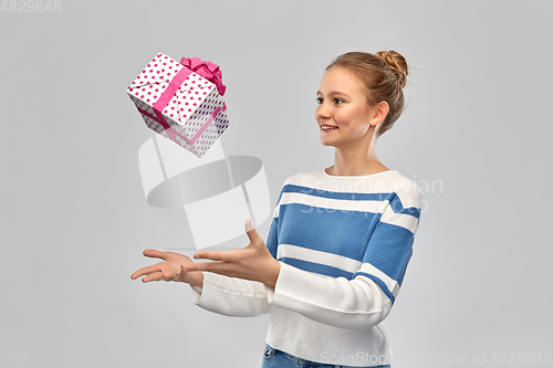 Image of smiling teenage girl in pullover with gift box