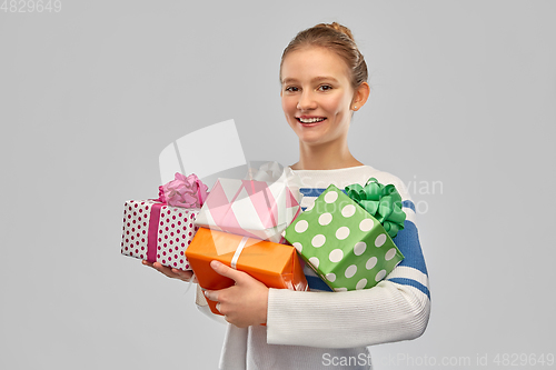 Image of smiling teenage girl in pullover with gift box