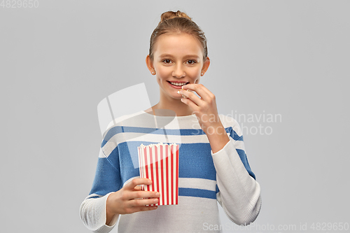 Image of smiling teenage girl eating popcorn