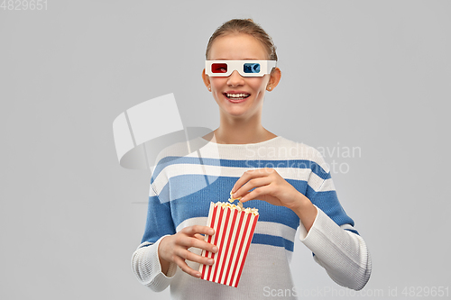 Image of teenage girl in 3d movie glasses eating popcorn