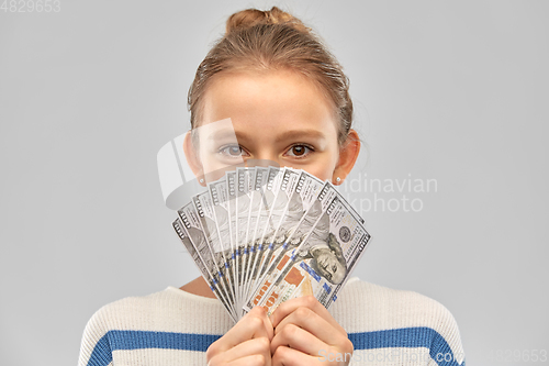 Image of smiling teenage girl with dollar money banknotes