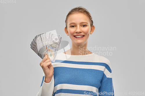 Image of smiling teenage girl with dollar money banknotes