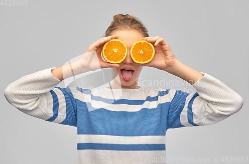 Image of funny teenage girl with oranges instead of eyes