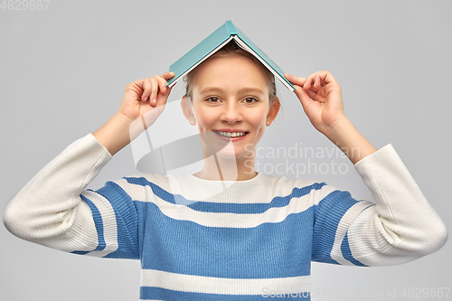 Image of happy smiling teenage student girl with book