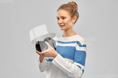 Image of smiling teenage girl r with digital camera
