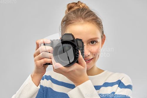 Image of smiling teenage girl r with digital camera