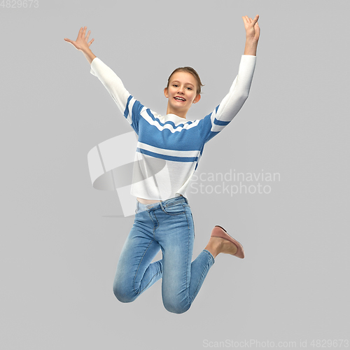 Image of smiling teenage girl in pullover jumping